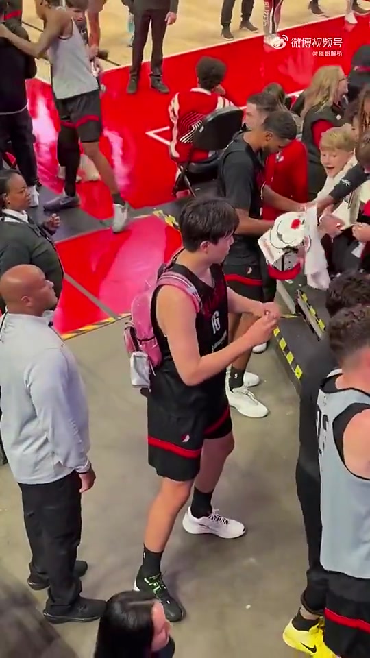 还不太熟练的样子杨瀚森背着粉色包包给球员通道球迷签名